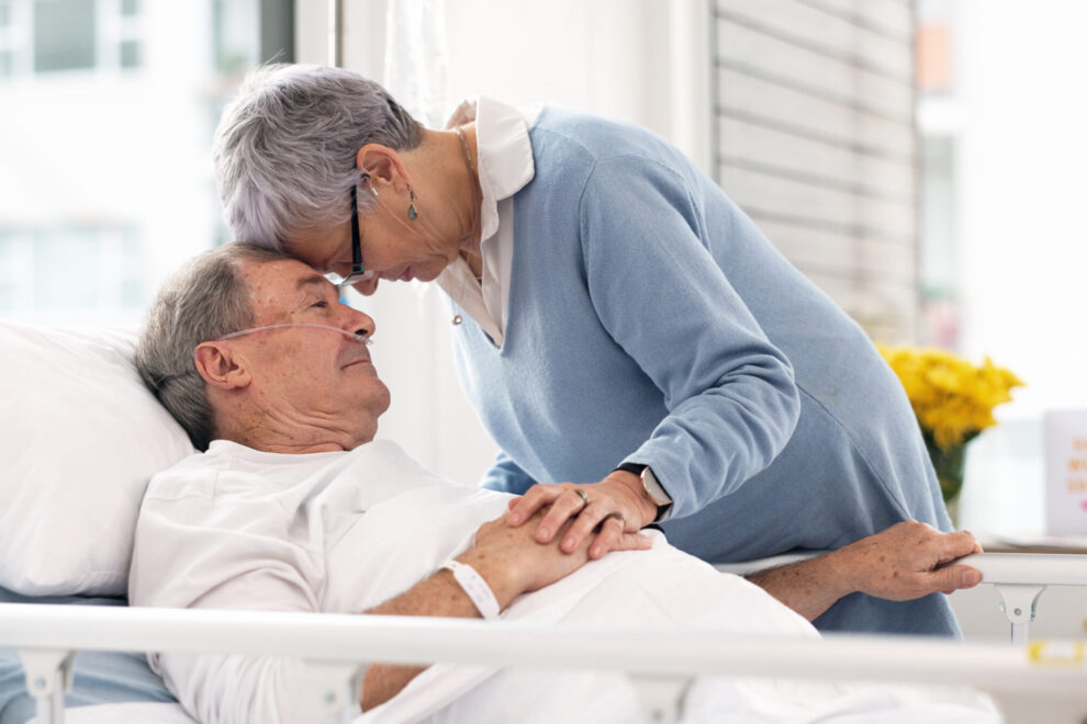Hospital, love or elderly couple, sick patient and affection for empathy, marriage bond and support for senior person. Retirement healthcare, forehead and man with medical problem, cancer or disease.